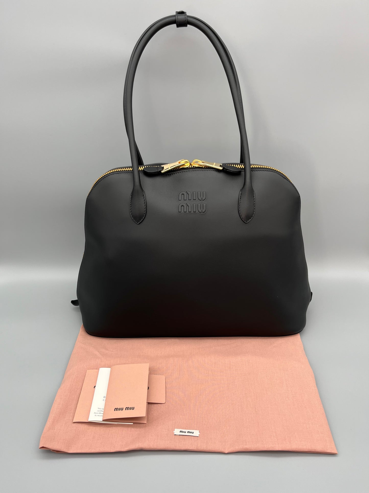 Miu Miu Schultertasche aus schwarzem Leder mit goldenen Akzenten - Luxuriöse Designer-Handtasche.